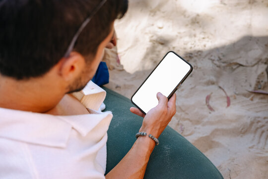 Man holding a phone with on the beach