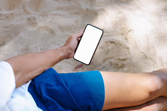 Man holding a phone with on the beach