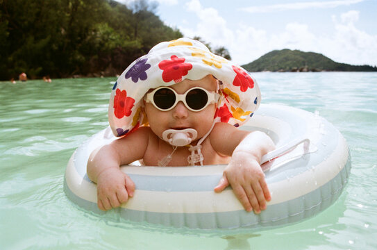 A toddler enjoys time spent in the ocean with an inflatable ring.