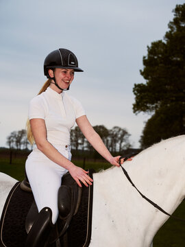 Rider on White Horse at a Training Event in the Evening Light