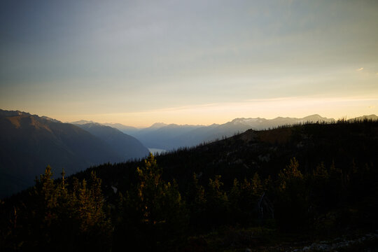 Mountains rise above trees at sunset in a quiet setting