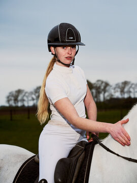 Rider Interacts With Horse on a Field During Late Afternoon