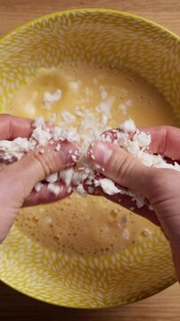 Crumbling Feta Cheese Into Bowl Close Up Top View Vertical