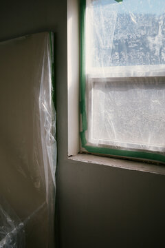 Plastic covers protect window and wall during home renovation task