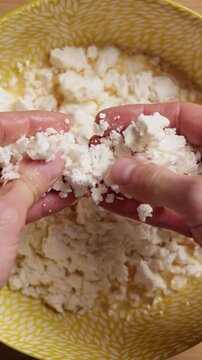 Crumbling Feta Cheese Into Bowl Extreme Close Up Top View Vertical