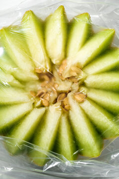 Fresh Cut Green Fruit in Plastic Wrap on a Table