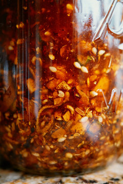 Homemade hot sauce with spices and oil in a glass jar