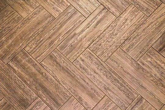 Modern luxury laminate parqet flooring with herringbone pattern in closeup for a background