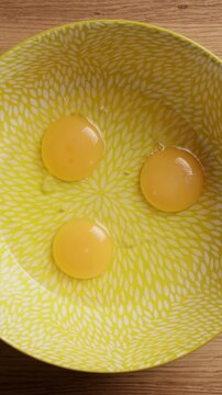 Pouring Eggs Into Bowl Top View Vertical