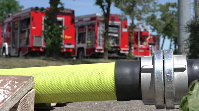 Fire Hose with Fire Trucks in Background 
