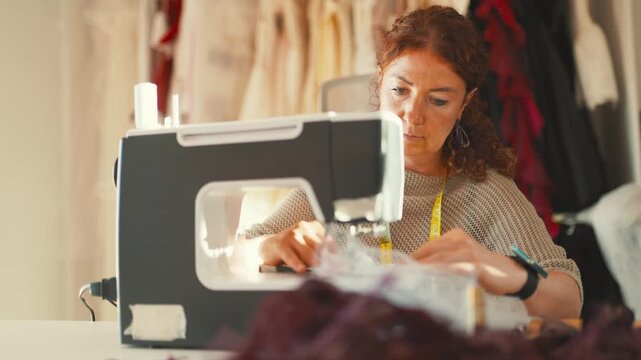 Sewing fabric in a workshop while creating clothes for an upcoming fashion event