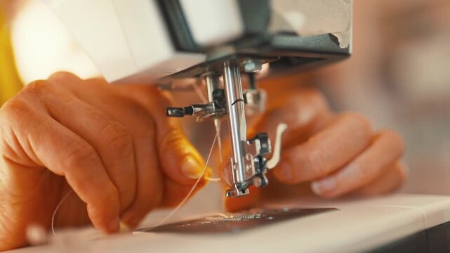 Sewing with a sewing machine in a workshop during daylight hours