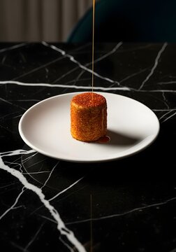 Mexican flan with caramel drizzle on a white plate with a black marble background