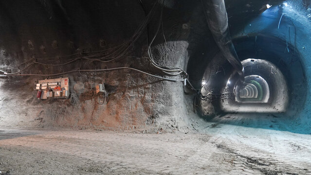View of a deep underground tunnel with rough rock walls, exposed wiring, and industrial lighting in Karabuk, Karabuk, Turkiye.