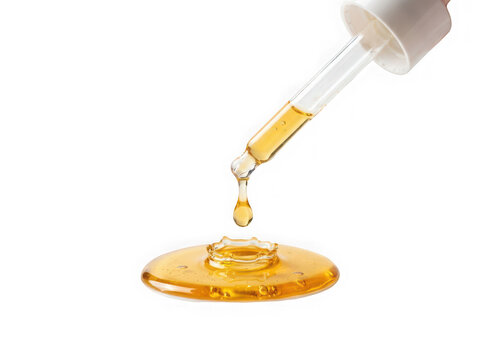 Pipette dropping golden yellow liquid isolated on transparent background