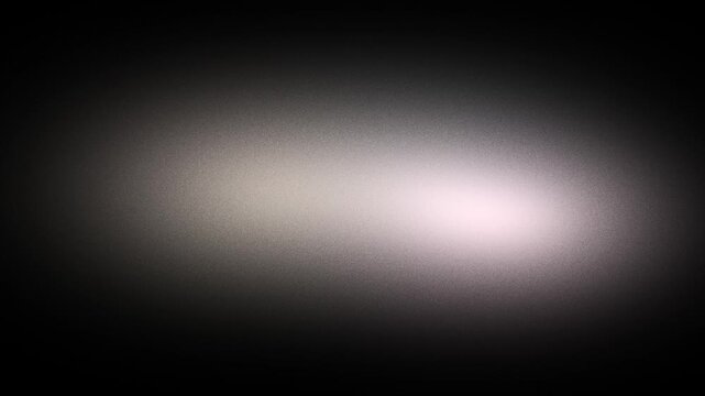 Soft white glow diffusing across a dark charcoal grainy field