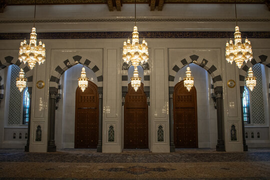 View of the ornate interior of the Sultan Qaboos Grand Mosque featuring crystal chandeliers and decorative arches in Muscat, Muscat Governorate, Oman.