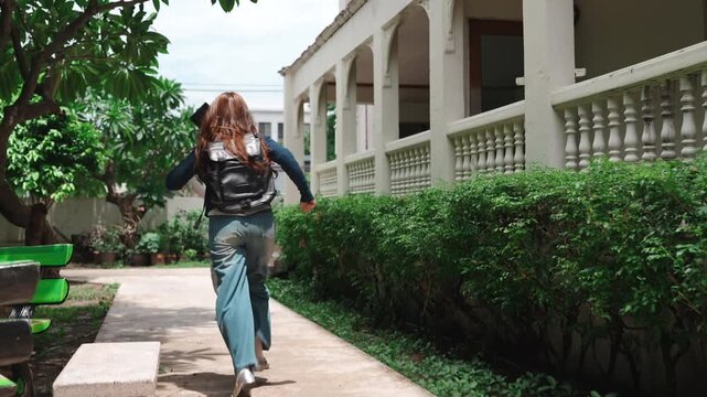 Happy women students meeting on campus. Excited friend running to greet with tablet and backpacks outside university building.
