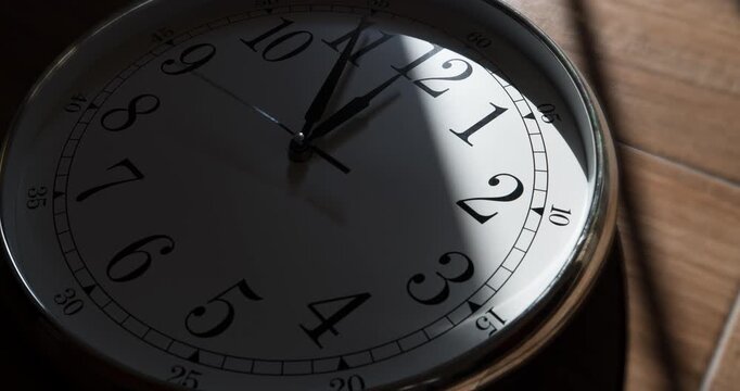 Wall clock show the running time. Time lapse on a modern wall clock.  Close up to a wall clock, with running time pointer. Sun and sky reflecting in the watch during the time passing by
