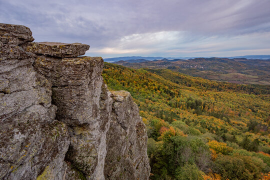 View of the rocky cliffs of Sitno in the Stiavnicke vrchy mountains overlooking a vast autumn forest with colorful foliage and rolling hills in Ilija, Banska Bystrica Region, Slovakia.