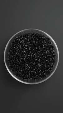 Rotating glass bowl filled with black polypropylene plastic granules and masterbatch resin pellets on black background, 3D render seamless Vertical video.
