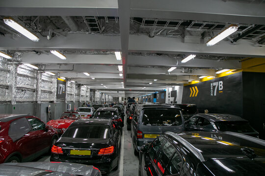 Crowded interior vehicle deck of a commercial car ferry operating on a cross-Channel route such as Dover to Calais. Cars and motorhomes are parked tightly together in designated loading zones marked
