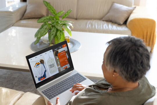 Senior African American woman sitting at right browsing Black Friday sale on laptop, copy space