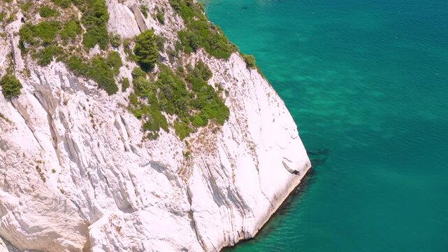 Sirolo Marche Italy 4k drone of Two Sisters beach Due Sorelle sunny day. Bright tropical turquoise sea water aerial white cliff reveal flight over rocky limestone stacks summer paradise b-roll