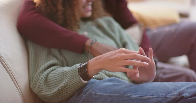 Couple on sofa with woman leaning back, partner holding embrace while woman rubbing bangle for calm