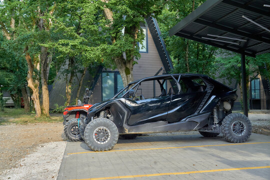 High‑Performance SSV with Oversized Tires: Sheltered Spot and Green Trees Background 