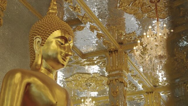 Beautiful golden interior of the Glass Vihara at Wat Phuttha Phrommayan temple in Chachoengsao, Thailand.