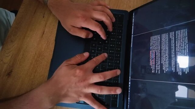 Man working at computer desk using keyboard and mouse in fast paced timelapse