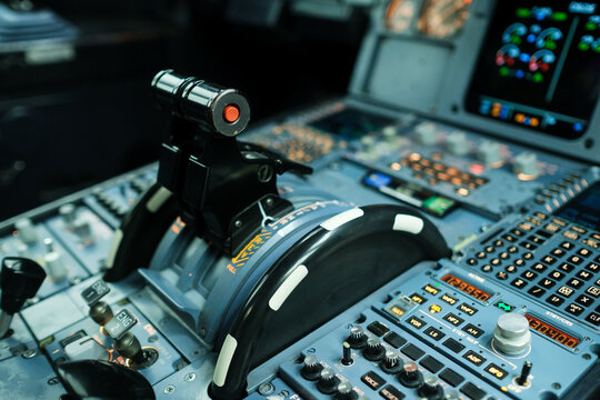 Control panel of an aircraft cockpit with various buttons, levers, and displays during a flight simulation
