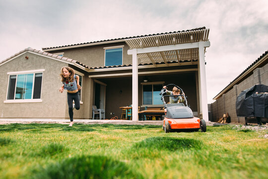 Boy cutting grass in backyard