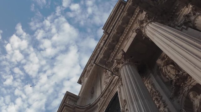 Stunning low angle view of the historic baroque imafronte facade of Santa Maria Cathedral in Murcia Spain highlighting intricate stone sculptures columns and architectural details under sky