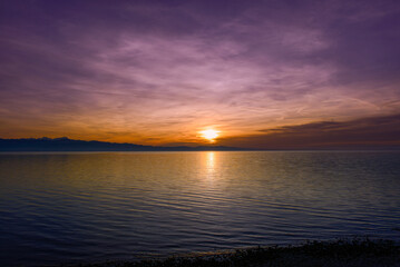 Obraz premium Spektakulärer violetter Abendhimmel über Wasserburg am Bodensee beim Sonnenuntergang mit Alpenpanorama