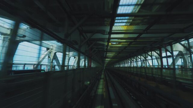 Daytime train window view of riding through the Rainbow Bridge truss structure in Tokyo, Japan