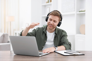 Fototapeta premium Man using video chat during webinar at table indoors