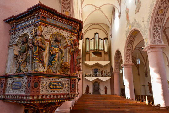 Blick auf die kunstvoll geschnitzte Kanzel und die Orgel im Kirchenschiff von St. Georg in Bischofsheim in der Rh&ouml;n