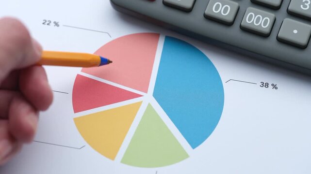 A businessman analyzing a colorful financial pie chart on a printed document using a pen. Close up.