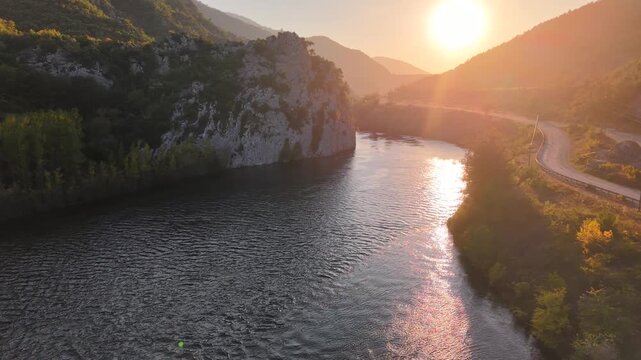 4K cinematic drone footage hovering steadily above a river during sunset. 