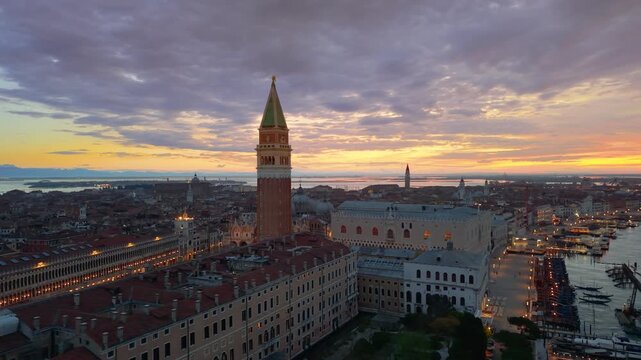 Venice aerial sunset over lagoon, boats gliding past basilica santa maria della salute, pastel sky casting. Italy