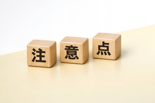 木製キューブで表す注意点ビジネスでの重要項目を解説