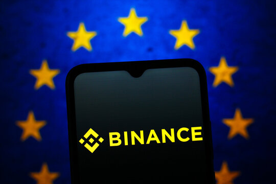 In this photo illustration, the Binance logo is seen displayed on a smartphone screen and the European Union flag in the background.