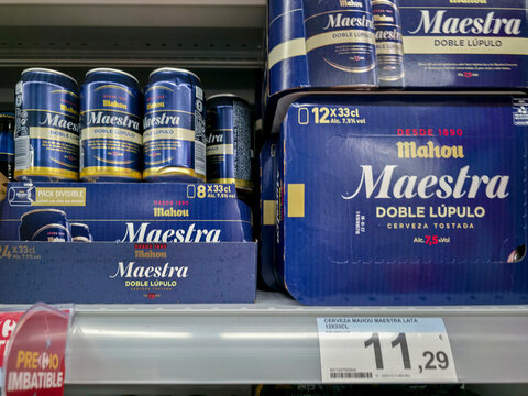 DENIA, SPAIN - Juny 18, 2026.Large cardboard packs and single cans of Mahou Maestra Doble Lupulo on supermarket shelf in Spain during afternoon shopping hours