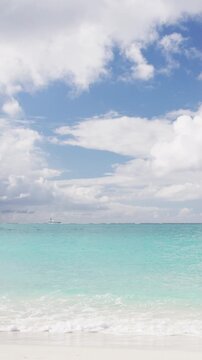 Beach background - Caribbean beach with turquoise water and white sand beach and blue sky. VERTICAL VIDEO IN SLOW MOTION.