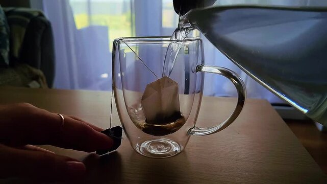 Brewing tea in a transparent mug using a tea bag