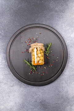 Pickled mushrooms in jar with rosemary and peppercorns