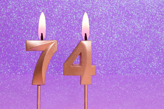 Number 74 on a pink background with blurred bright dots - Birthday or anniversary card with abstract blurred dots that glow