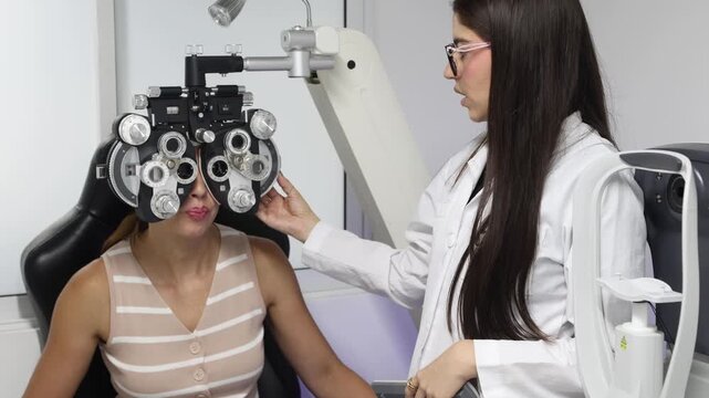 Optometrist adjusting phoropter settings during eye exam consultation